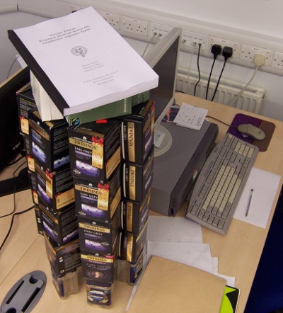 A PhD thesis on top of a big stack of empty tea boxes.